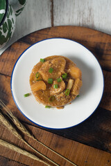 Cow skin meat cooked with spicy peanut sauce with onion leaves as garnish. 
