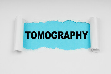 In the middle of a white sheet in space on a blue background the inscription - Tomography