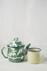 Stripes vitreous enamel teapot and glass isolated on white background