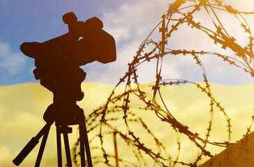 Double exposure - camera, barbed wire and flag Ukraine
