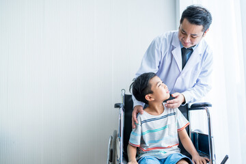 Male doctor standing, caring and cheering for a boy patient sitting in a wheelchair by the window.