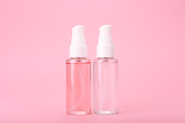 Two different face lotion, liquid foam or gel for skin cleaning in transparent tubes on bright pink background