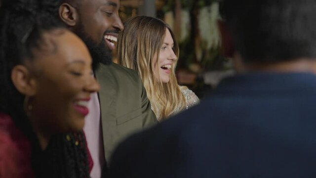 Tracking Shot of a Group of Friends Talking and Laughing In a Bar