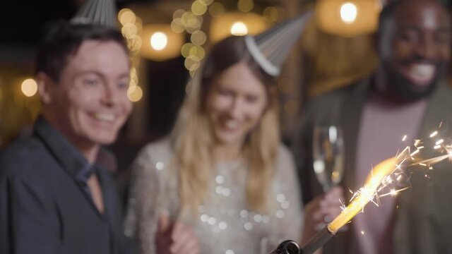 Close Up Shot of Champagne Sparkler as Friends Celebrate New Years Eve