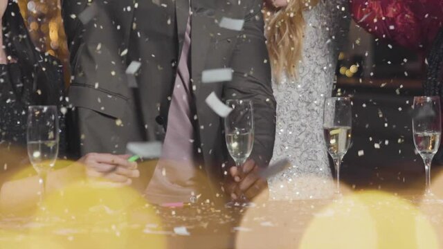 Close Up of Confetti Falling on Friends Celebrating New Years Eve
