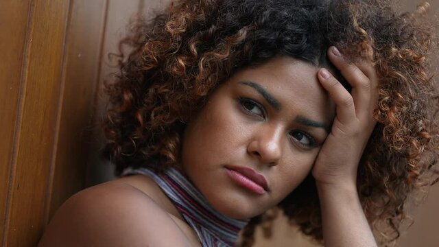Pensive Brazilian woman thinking deeply about problems