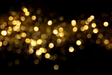 Golden blurred bokeh lights on black background. Glitter sparkle stars for celebrate. Overlay for your design