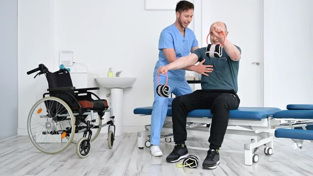 Man with disability doing recovery exercise with dumbbell. Disabled handicapped person in recovery support therapy physiotherapy healthcare system. High quality 4k footage