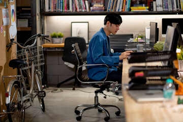 Smart Asian business man with casual cloth work in office with bicycle park near his workplace. Concept of save the world use vehicle that no produce carbon to environment.
