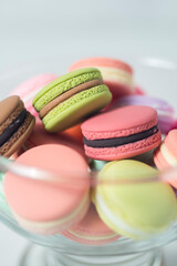 Artificial mini French macarons with various colors on glass isolated on white 