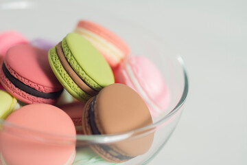 Artificial mini French macarons with various colors on glass isolated on white 