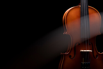 A streak of light cutting through a violin or viola on a black background