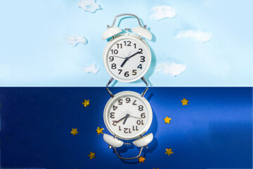 Circadian rhythms with white alarm clock, night and day backgrounds 