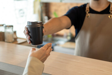 Fototapeta na wymiar Cafe. friendly barista serving hot coffee cup to happy female customer over counter in modern cafe coffee shop, cafe restaurant, service mind, hot coffee ,small business owner food and drink concept