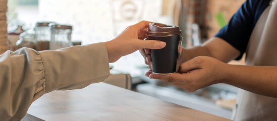 Coffee. friendly barista serving hot coffee cup to happy female customer over counter in modern cafe coffee shop, cafe restaurant, service mind, hot coffee ,small business owner food and drink concept