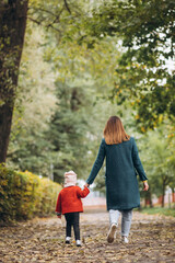 Obraz premium Young mother with her little daughter in an autumn park