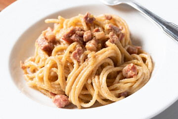Piatto di cremosi spaghetti alla carbonara con uovo, pecorino e pancetta, Cucina Italiana 