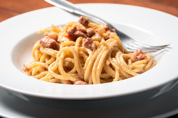 Piatto di cremosi spaghetti alla carbonara con uovo, pecorino e pancetta, Cucina Italiana 
