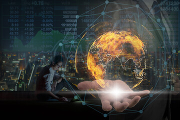 Double exposure of Businessman hand holding the particle earth with technology network circle over Asian businessman using laptop showing the Stock market chart over the cityscape