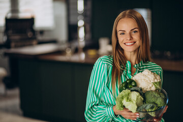 Young woman smiling and holding cauliflower