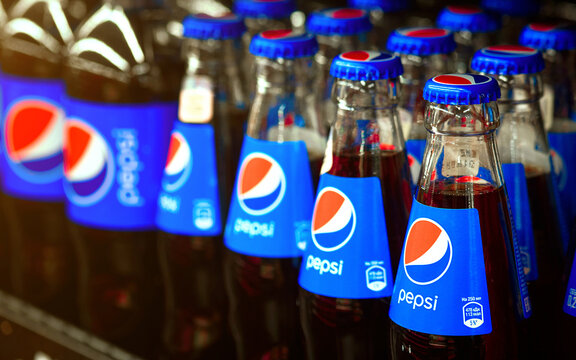 Minsk, Belarus. Nov 2021. Pepsi drinks in small glass bottles displayed on shelf for sale in supermarket. Showcase with PepsiCo drinks closeup. PepsiCo - American multinational beverage corporation