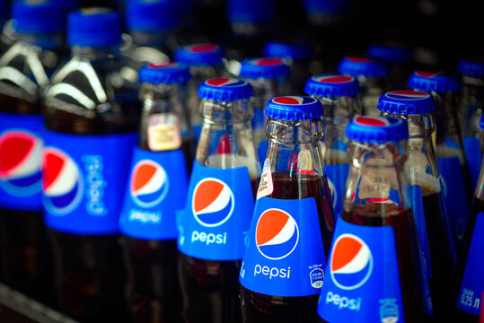 Minsk, Belarus. Nov 2021. Pepsi drinks in small glass bottles displayed on shelf for sale in supermarket. Showcase with PepsiCo drinks closeup. PepsiCo - American multinational beverage corporation