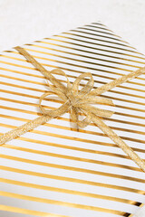 Fototapeta na wymiar Close up, cropped of christmas gifts boxes wrapping in white gold paper with bow for family lying on fluffy snow-white carpet. Top view