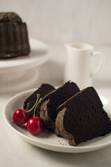 Slices of chocolate cake with strawberry garnish against white background