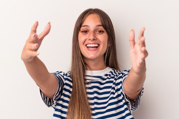 Young caucasian woman isolated on white background celebrating a victory or success, he is surprised and shocked.