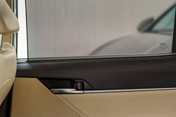 Opened sunshade. Car side window curtains sunshades. Sunblind curtain in a modern car.