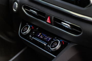 Obraz na płótnie Canvas Red triangle hazard light button on car dashboard. Car media buttons dashboard. Detail of a modern car controllers.