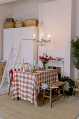 Christmas table in the house Pink interior Red flowers and a classic style chandelier