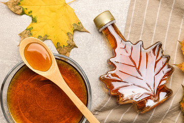 Flat lay composition with tasty maple syrup and dry leaves on light grey table