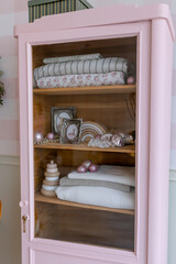 Pink wardrobe in the children's room with bedding and toys