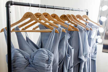 Blue bridesmaids dresses used for a wedding hanging on the hanger A few beautiful wedding dresses on a hanger Clothes for bridesmaids dresses hanging on trempel Close-up of the bridesmaids' dresses - obrazy, fototapety, plakaty