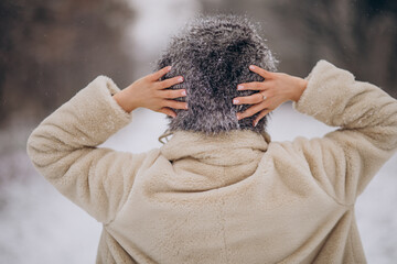 Woman posing from the back and walking in winter park