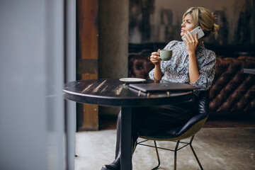 Woman working on computer and drinking coffee