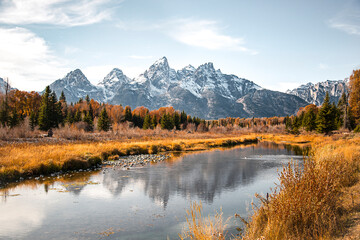 Fototapeta na wymiar Teton mountain range reflection in the Snake River at Schwabacher's Landing in Grand Teton National Park, Wyoming. Fall scenic nature landscape with evergreen trees and a mountain water reflection.