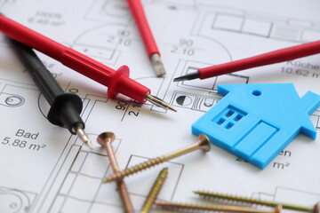 a screwdriver with a gauge and a toy house on a circuit diagram