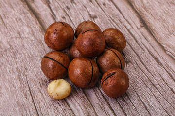 Brown macadamia nut heap over background