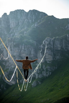 Camminare in equilibrio sulla corda slackline a grandi altezze tra le montagne