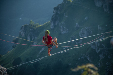 Camminare in equilibrio sulla corda slackline a grandi altezze tra le montagne