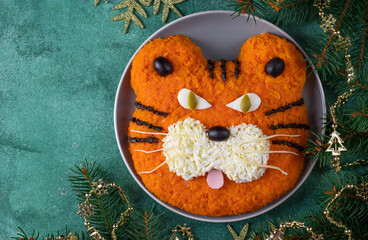Festive Tiger-shaped salad for 2022 on green background, Symbolic food for new year. Top view, Copy space
