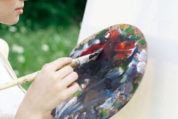 woman artist paints palette easel nature drawing
