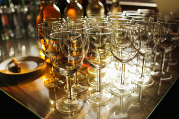 Wine glass background. Alcohol banquet table. Restaurant event celebration. Shiny alcohol empty glasses. Plenty of wineglass with wine bottle in the background. Wedding reception.