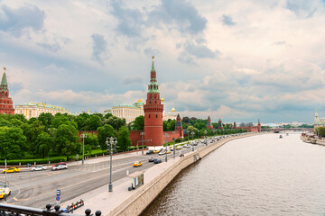 Obraz premium view from the bridge to the towers of the Moscow Kremlin and the Moskva River embankment against the background of a cloudy sky. Moscow. Russia