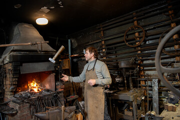 a blacksmith throws a hammer in his workshop