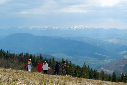 Group of people meditates on the nature overlooking the beautiful mountains