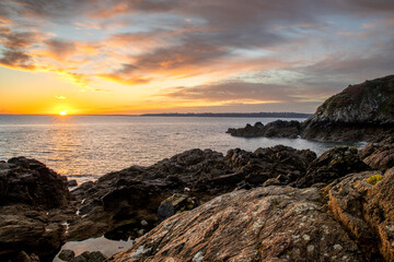 Cr&eacute;puscule sur la mer avec un beau ciel dor&eacute; et des rochers en avant-plan  (Bretagne, France)