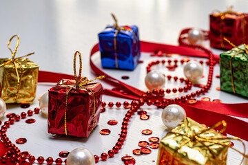 Multicolored Christmas gifts and decorations on a white wooden background